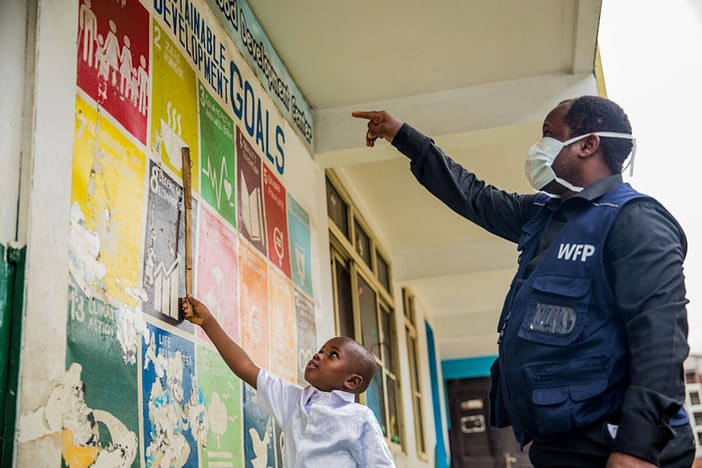 World Food Programme (WFP) staff member teaches David, a student, about the Sustainable Development Goals at a distribution centre for the National Home Grown School Feeding Programme supported by WFP in Nigeria. 