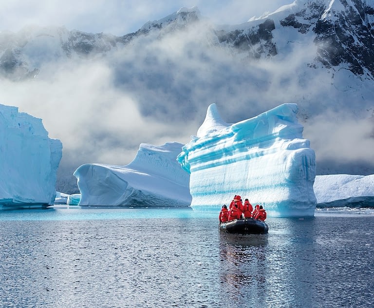 Guests from the Lindblad Expedition ship National Geographic Explorer enjoy icebergs at Booth Island, Antarctica by Zodiac.